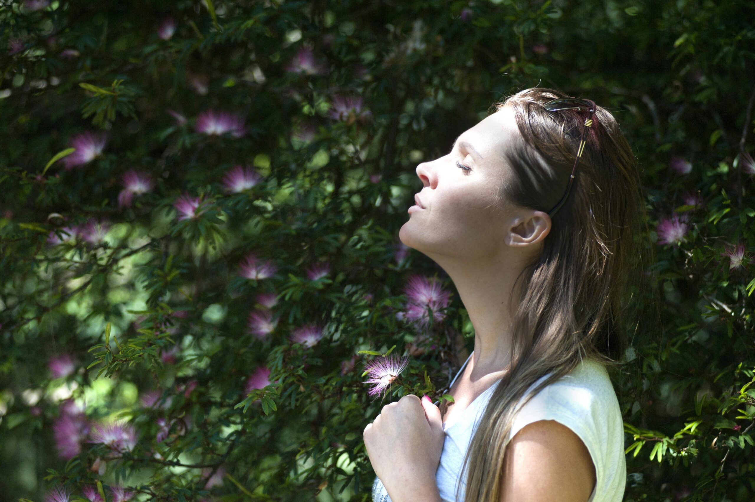 woman taking a deep breath and practicing meditation against a leafy and floral background