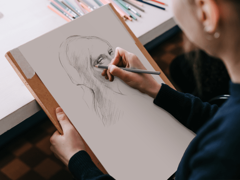 Young girl drawing a portrait close up